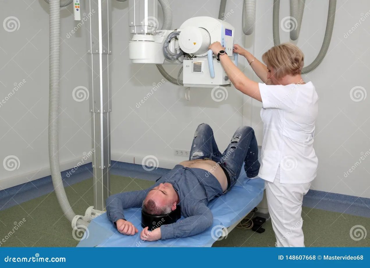 Radiologists Performing Xray on Patient. Technician Setting Up Machine